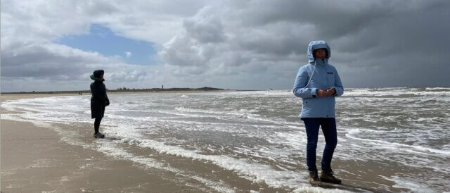 two women standing in the surf of the sea