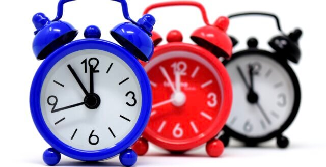 Three alarm clocks showing five to twelve, a reminder to catch the warning signs before a wake-up call.